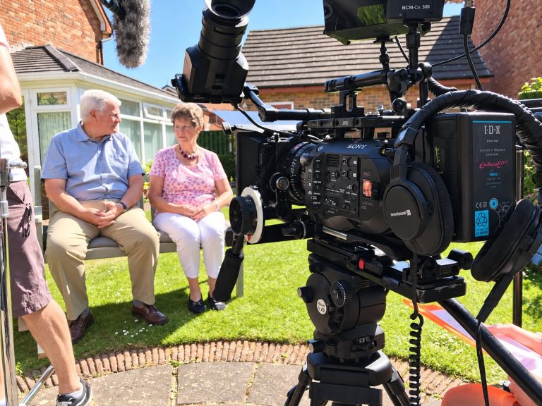 A couple being filmed in their garden for a customer testimonial