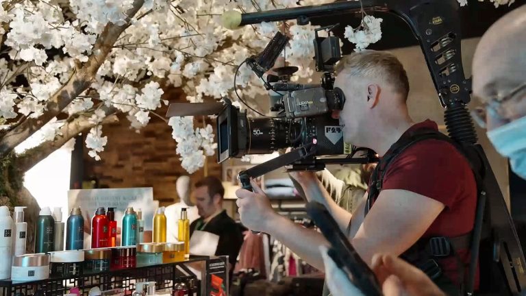 A camera operator filming inside a shop