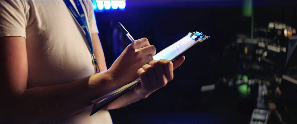 Someone writing notes on a clipboard