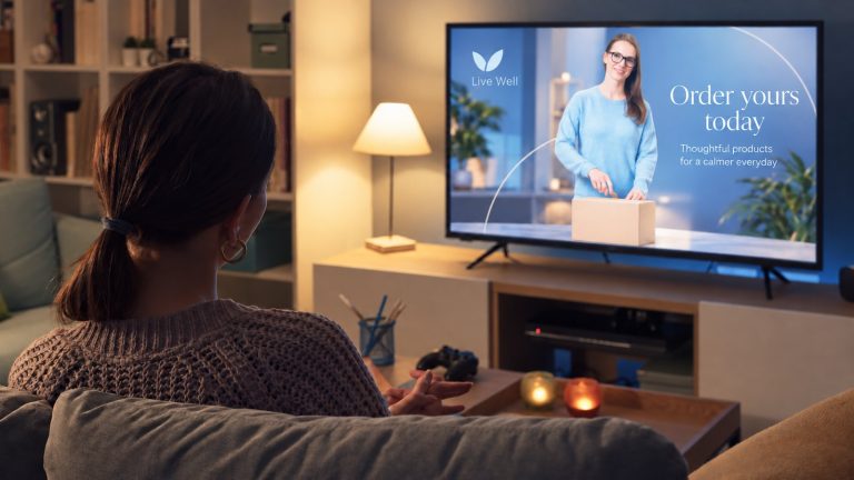 Someone at home on the sofa watching an advert on television