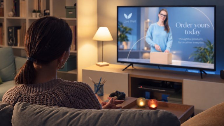 Someone at home on the sofa watching an advert on television