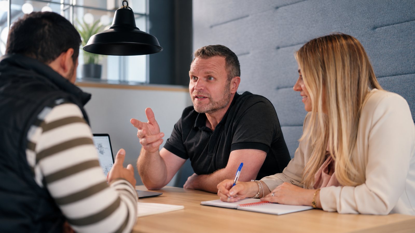 Mark and Amanda from TVads talking through a brief with a client at a table